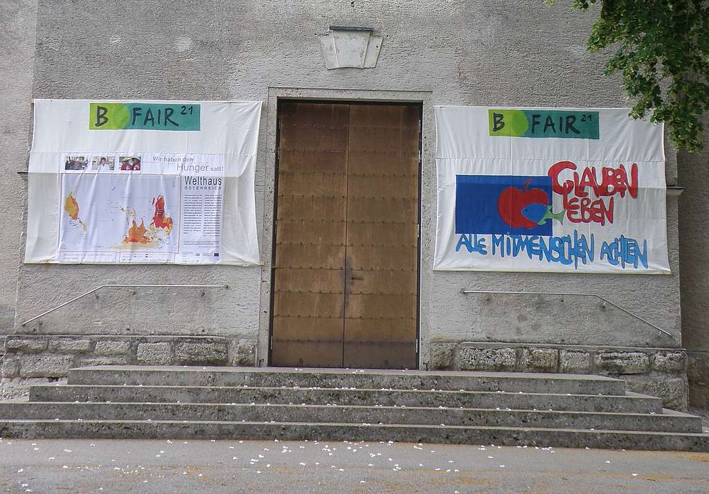 Plakate mit nachhaltigen Botschaften hangen am Eingangsportal der Pfarrkirche Sattledt.
