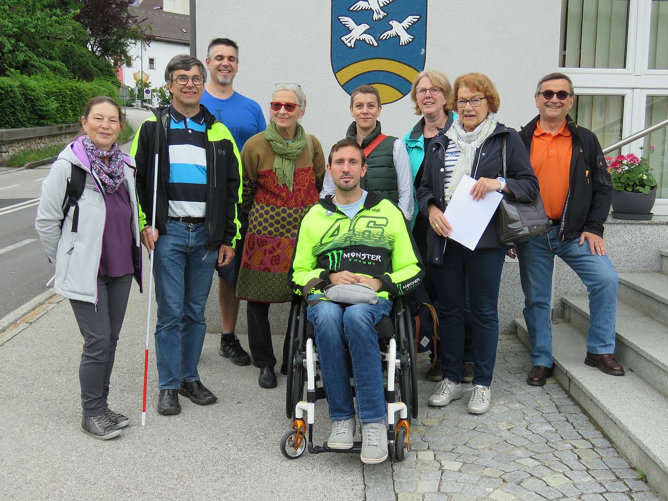 Neun Personen suchen in Traunkirchen vor dem Gemeindeamt nach Hürden für körperlich beeinträchtigte Menschen.