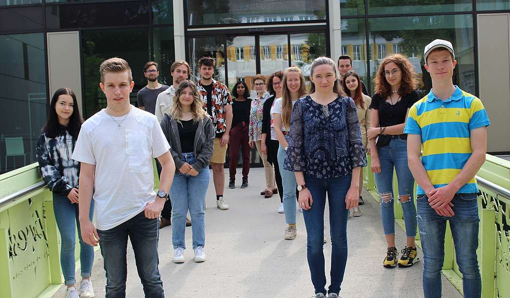 Gruppenfoto von 14 jungen Menschen vor einem Haus.